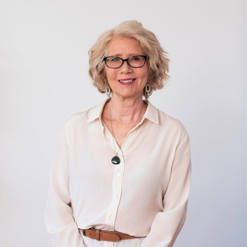 A portrait photo of Dr Sally Rimkeit who is smiling warmly and wearing a cream blouse